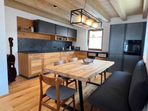 a kitchen with a wooden table and chairs at Chalet Maris in Fieberbrunn
