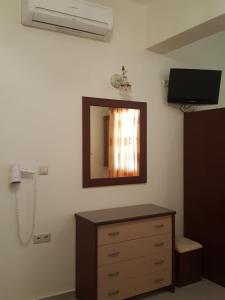 a room with a dresser and a mirror on the wall at Apartments Anna Maria in Agia Anna Naxos