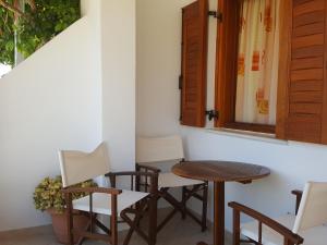 a table and chairs in a room with a window at Apartments Anna Maria in Agia Anna Naxos