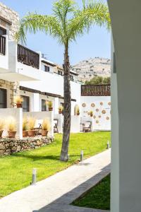 a palm tree in the courtyard of a house at Costa Lindia Blue Star - Adults Only in Lartos