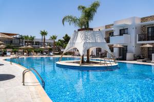 a resort swimming pool with a slide in the middle at Costa Lindia Blue Star - Adults Only in Lartos