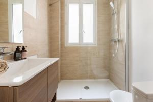 ルヴァロワ・ペレにある2 pièces-Moderne-Proche Parisの白い洗面台とシャワー付きのバスルーム