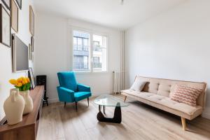 ルヴァロワ・ペレにある2 pièces-Moderne-Proche Parisのソファと青い椅子のあるリビングルーム