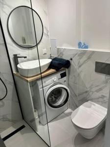 a bathroom with a sink and a washing machine at A&P Studio in Gdynia