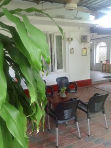 a table and chairs in a room with a plant at New Hamsam Villa in Kallady