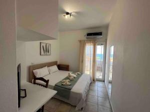 a bedroom with a bed and a table and a window at Effies Apartments in Karlovasi