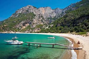 a beach with two boats and a dock in the water at Effies Apartments in Karlovasi