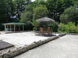 una mesa y sillas bajo una sombrilla en la arena en La Vergne, en Saint-Martin-des-Combes
