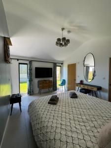 a bedroom with a large bed and a flat screen tv at Lavish Dorset countryside retreat in Bradpole