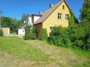 a yellow brick house with a yard at Lohusuu Kortermajutus in Venekyula