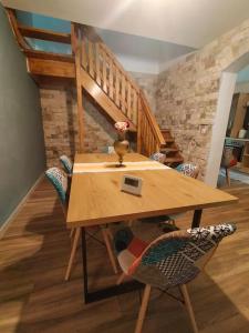 a wooden table and chairs in a room with a staircase at Tarnita Summer House in Someşu Cald