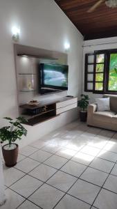 a living room with a flat screen tv on a wall at Jo's Casa 21 in Porto Seguro