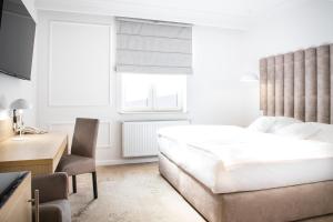 a bedroom with a bed and a desk and a chair at Europejski Boutique Hotel in Radom
