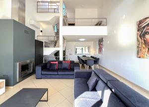 a living room with a blue couch and a table at Fantastic Villa, Private Pool, BBQ, AC and Wi-Fi in Quarteira