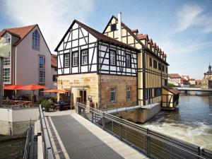 a building next to a river with a boat at Hotel Nepomuk in Bamberg
