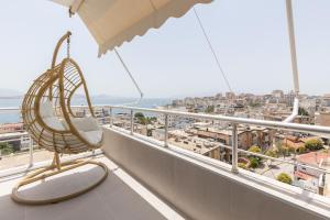 einen Stuhl auf einem Balkon mit Stadtblick in der Unterkunft The View - Ruby, Luxury, Central in Sarandë
