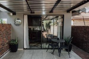 a patio with a table and chairs and a kitchen at The Only Guestroom in Kathu