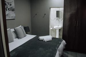 a bedroom with a bed with a sink and a mirror at The Only Guestroom in Kathu