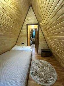 un lit dans une chambre avec un plafond en bois dans l'établissement Hillside Borjomi Two chalet, à Bordjomi