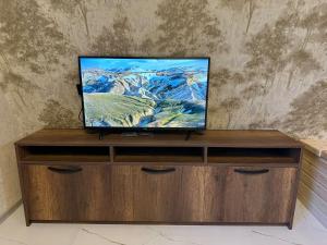 a flat screen tv sitting on top of a wooden entertainment center at Hillside Borjomi Two chalet in Borjomi
