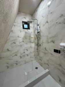 a white bathroom with a shower and a tub at Hillside Borjomi Two chalet in Borjomi +71 photos