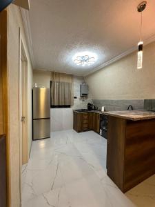 une grande cuisine avec un réfrigérateur en acier inoxydable dans l'établissement Hillside Borjomi Two chalet, à Bordjomi