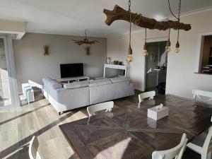 a living room with a couch and a television at Majestic in De Panne