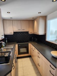 a kitchen with wooden cabinets and a sink at Majestic in De Panne +3 photos
