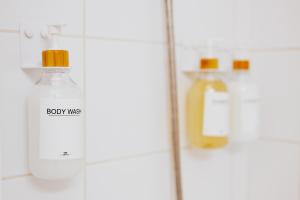 a shelf with two bottles of body wash on it at Le Cocon de Lespinasse - Parking - Checkin Autonome in Lespinasse +62 photos