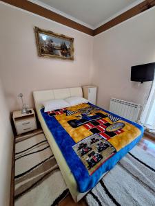 un letto con una trapunta in una camera da letto di Apartman IN a Divčibare