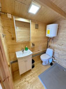 a wooden bathroom with a toilet and a sink at Floating Camp House in Jūrmala