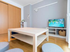 a living room with a wooden table and a tv at utazu stop in Utazu