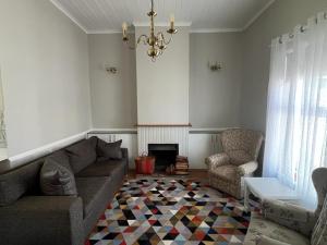 a living room with a couch and a chair at Sage Cottage in Somerset West