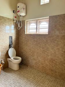 ein Badezimmer mit Toilette und Fenster in der Unterkunft Heritage Haven Retreats in Madikeri
