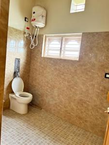 ein Badezimmer mit Toilette und Fenster in der Unterkunft Heritage Haven Retreats in Madikeri