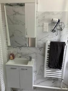 un bagno bianco con lavandino e specchio di Zsuzsa Vendégháza a Balatonfüred