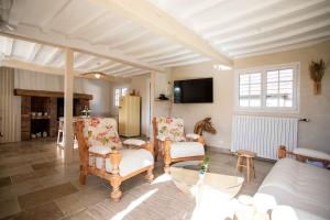 ein Wohnzimmer mit Sofa, Stühlen und einem Tisch in der Unterkunft La Longère avec Piscine in Saint-Martin-le-Gaillard