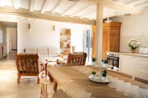 eine Küche und ein Wohnzimmer mit Tisch und Stühlen in der Unterkunft La Longère avec Piscine in Saint-Martin-le-Gaillard