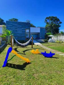 a playground with a slide and a hammock at Brisa Mar Suítes in Arraial d'Ajuda