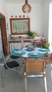 a table with chairs and a table with plates and dishes at Brisa Mar Suítes in Arraial d'Ajuda +4 photos