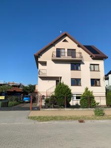 a white building with a black roof at Pokój - Nad Zatoką in Jastarnia