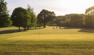 a group of people playing golf on a golf course at Rodway Hill Golf & Eco Pod Hotel in Gloucester +11 photos