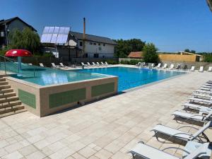 a large swimming pool with lounge chairs and areens at BC Aprilia in Corbu