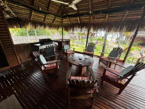 a porch with a table and chairs and a stove at Repousante Beach House in Morrumbene