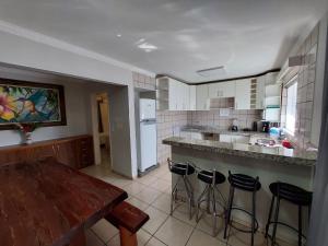 a kitchen with a table and some bar stools at diRoma Fiori C/Cozinha e Parque Aquático - Wafeh in Caldas Novas