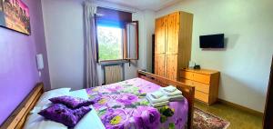 a bedroom with a purple bed and a dresser at Villa Sartori in Legnago