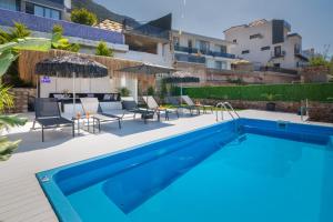a swimming pool with chairs and a table next to a building at Suite La Mer in Kalkan
