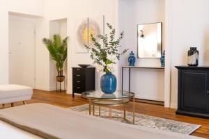 a living room with a blue vase on a glass table at La Duca Suites & Apartments in Palermo