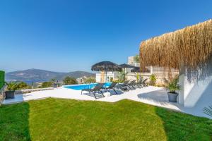 a villa with a pool and a grass yard at Suite La Mer in Kalkan