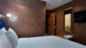 a bedroom with a white bed and a wooden wall at Aselia Hotel Trabzon in Trabzon